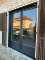 Porte-fenêtre simple en PVC de couleur noir avec des volets en bois 