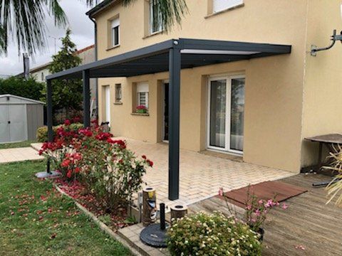 Pergola accolée à une maison aux façades jaunes