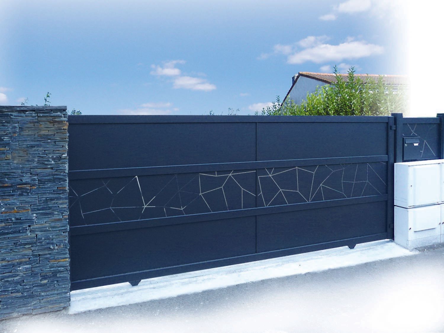 Portail coulissant bleu sombre avec des motifs en partie centrale sur toute la longueur