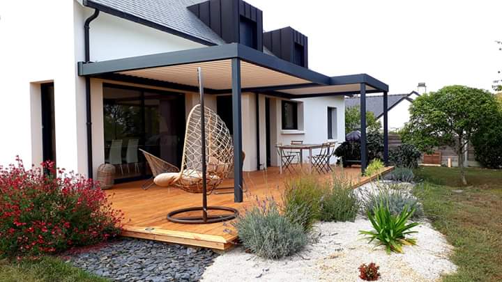 Terrasse en bois avec grande pergola au-dessus et siège hamac en premier plan