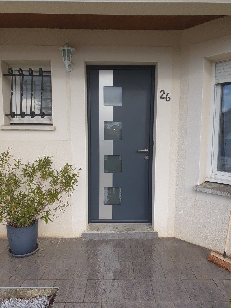 Porte noire avec un design en relief et des inserts en acier.