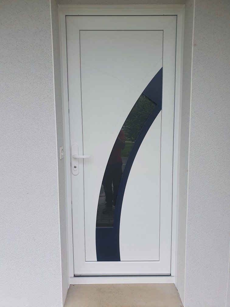 Porte d'entrée en blanc traversée d'un arc de clercle en verre