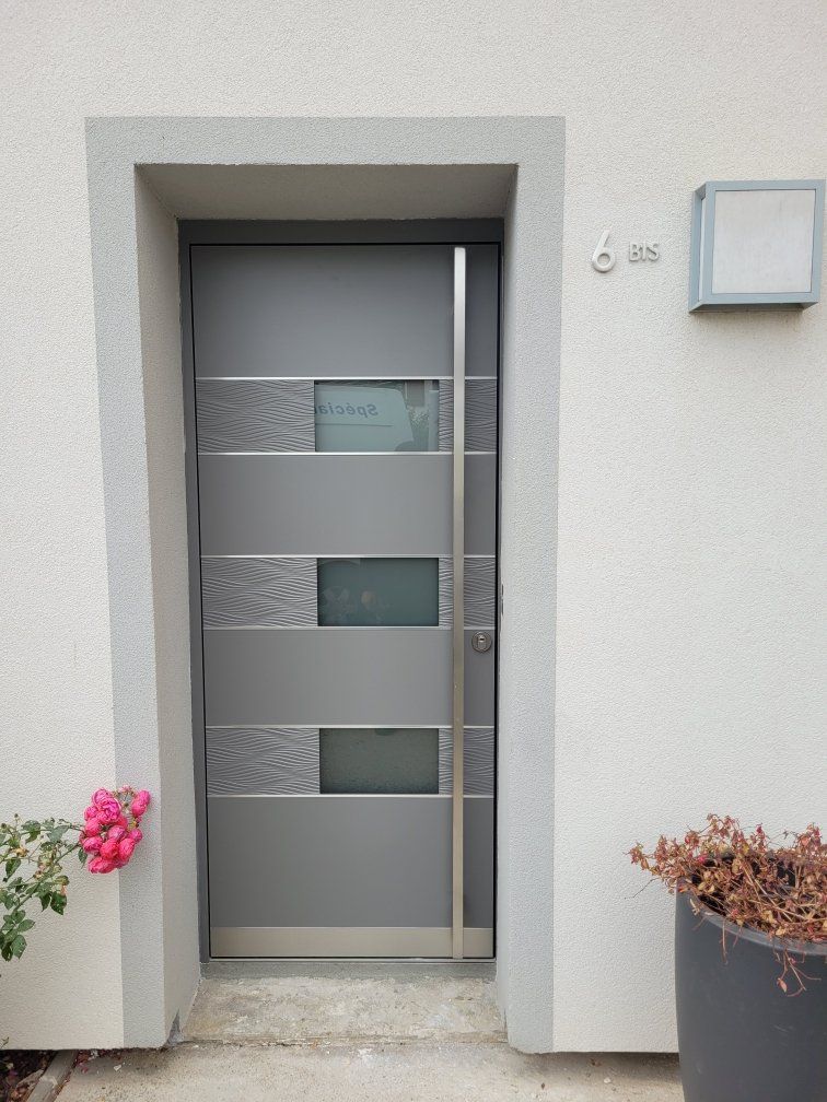 Porte noire au style industriel avec des panneaux de verre fumé intégrés.