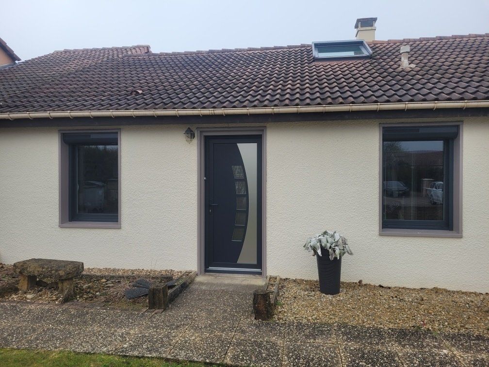 Devanture d'un pavillon de plain-pied avec deux fenêtres et une porte d'entrée design au centre