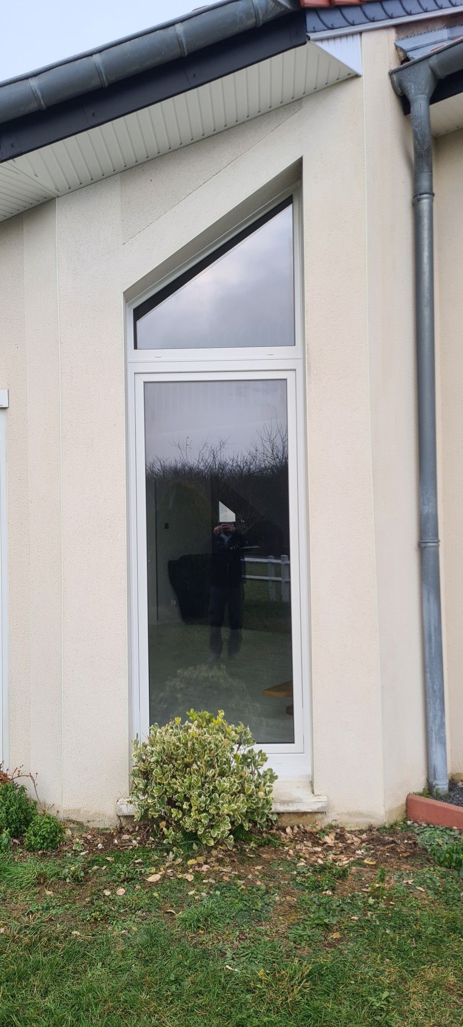 Fenêtre d'une maison en long avec forme trapézoïdale au-dessus