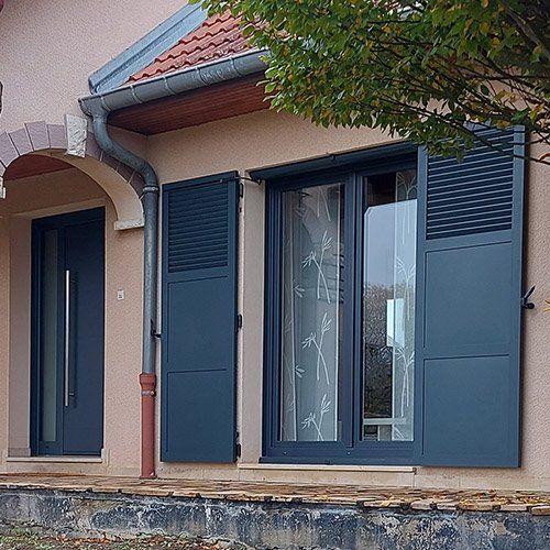 Fenêtre avec armature en aluminium noir et volet de couleur assortie