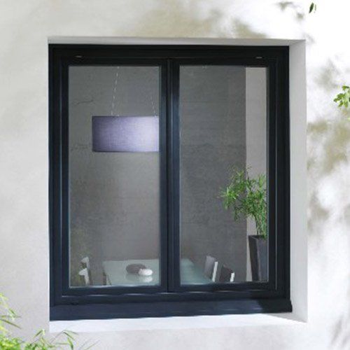 Fenêtre noire dans un mur blanc donnant sur une table à manger