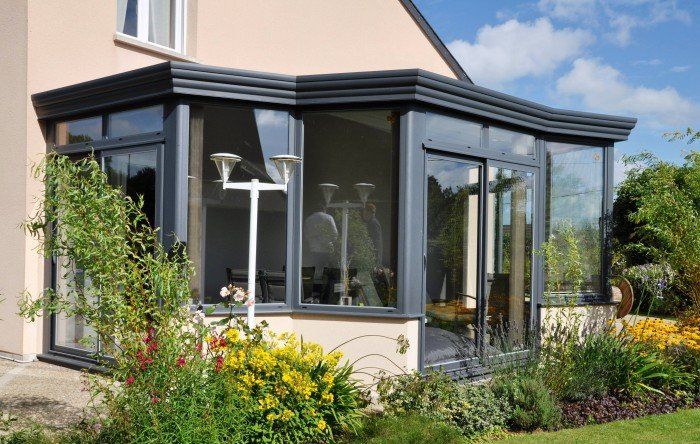 Grande véranda de couleur grise et grande baie vitrée