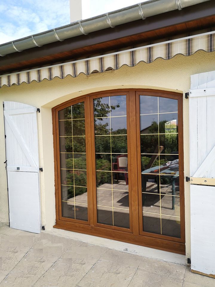 Grande porte-fenêtre en bois avec une grande ouverture et cintrée