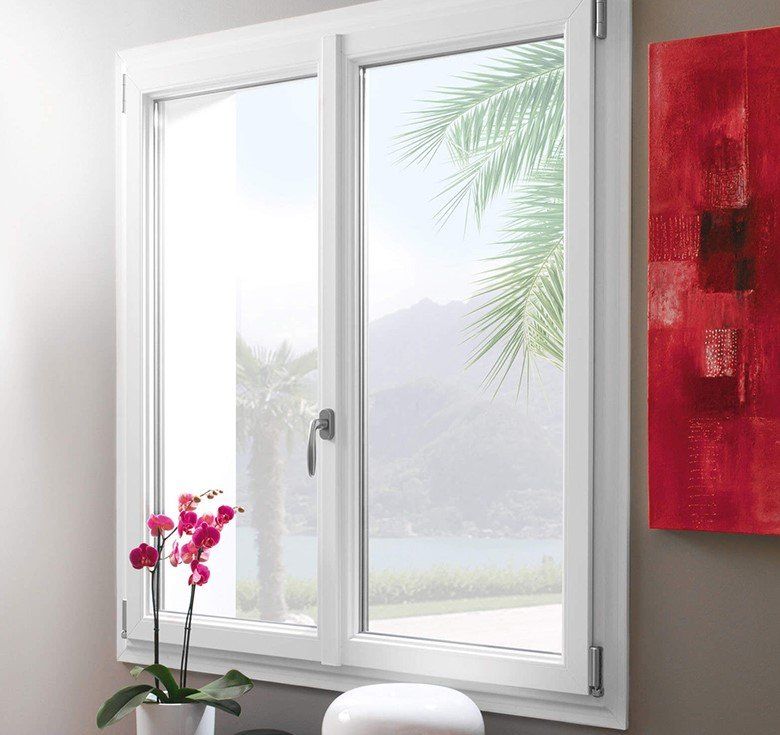 Fenêtre en PVC blanche vue depuis l'intérieur d'un salon avec des orchidées devant et un tableau rouge sur la droite