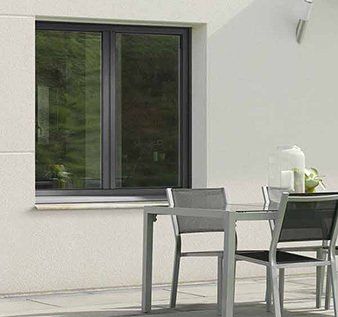 Fenêtre en PVC sombre donnant sur une table à manger d'extérieur vue de près