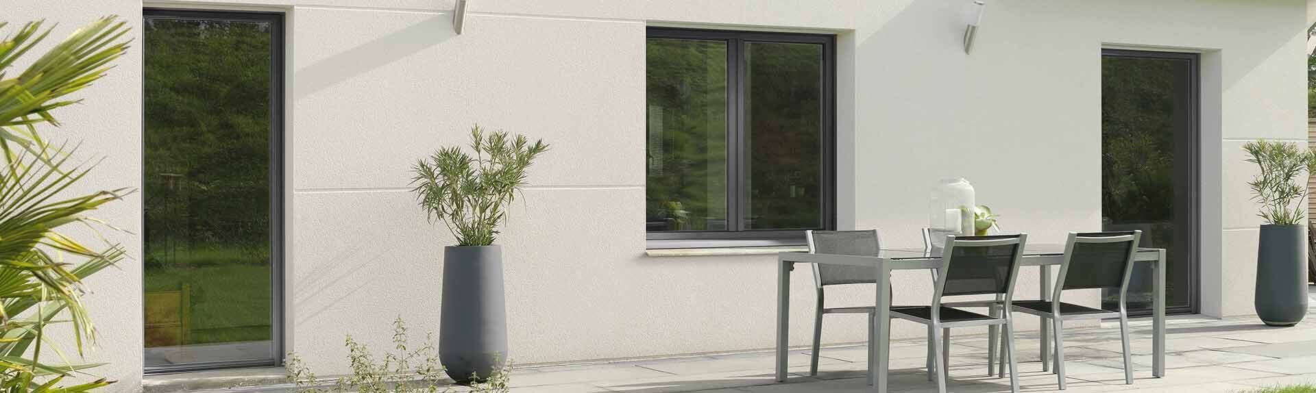 Fenêtre en PVC sombre donnant sur une table à manger d'extérieur