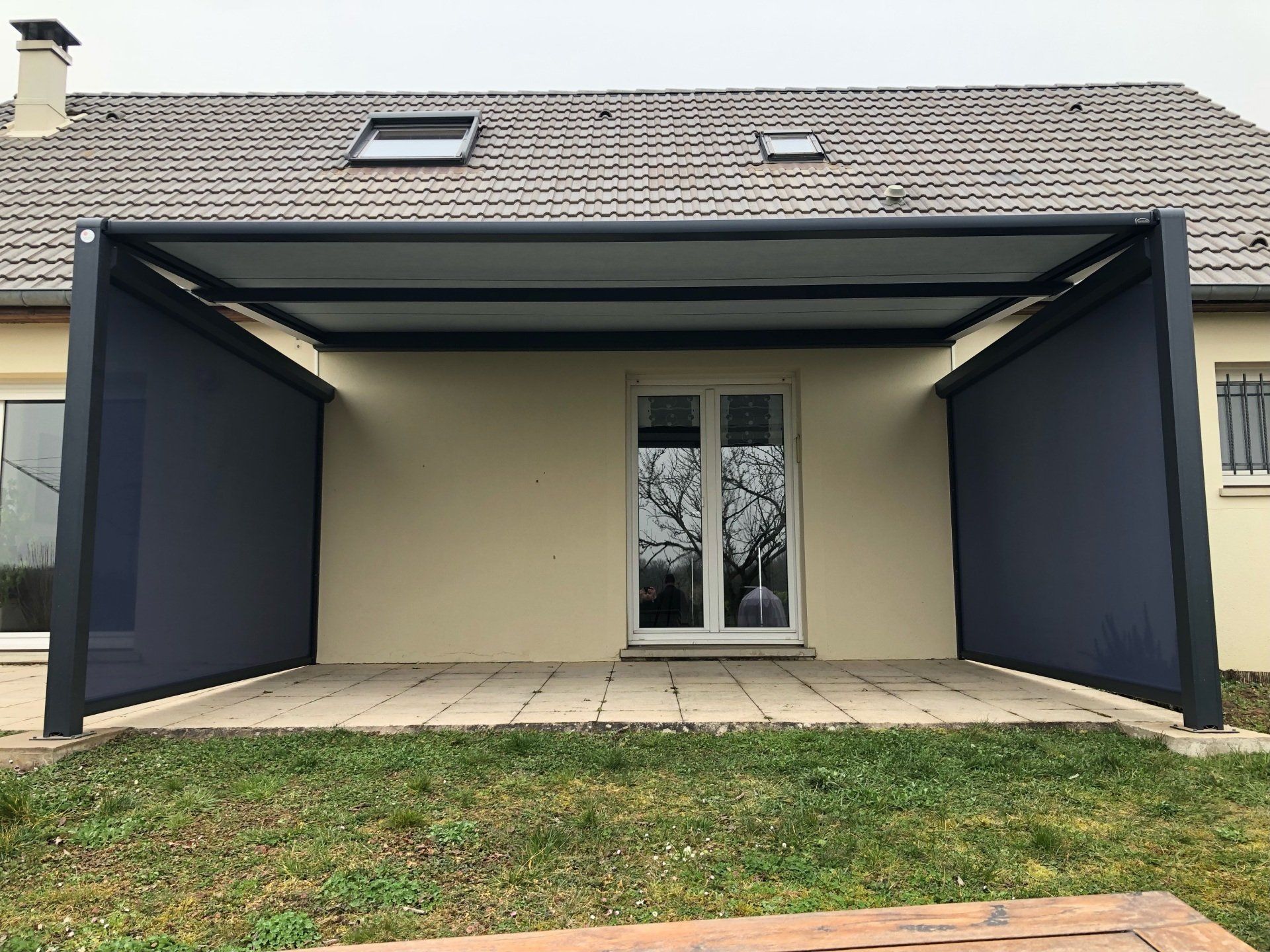 Stores bannes et occultant sur les côtés devant une terrasse en bois