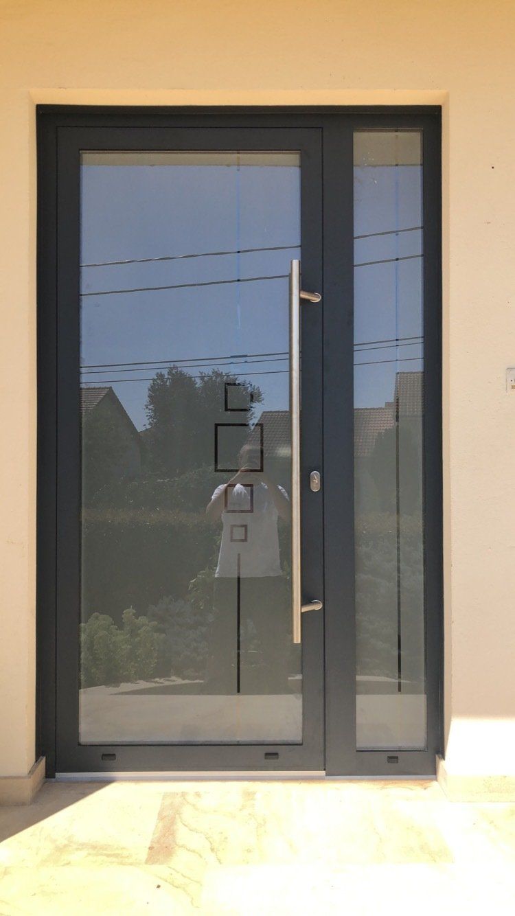 Porte d'entrée bleu sombre avec corps en verre agrémenté de motifs géométriques