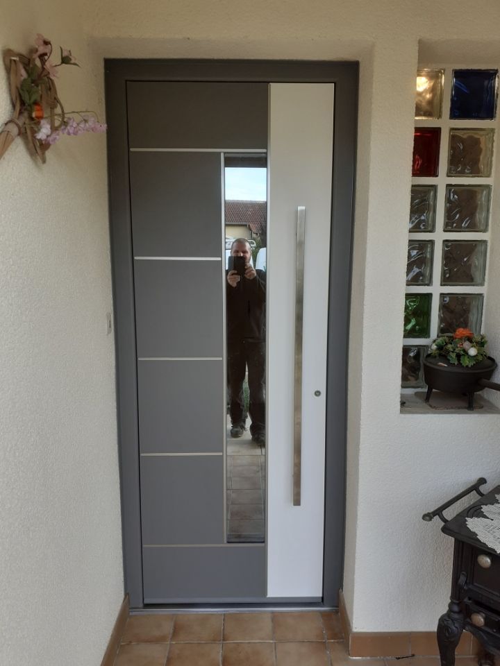 Porte d'entrée composée d'une partie à droite blanche, d'une partie au centre en miroir, et d'une partie à gauche grise