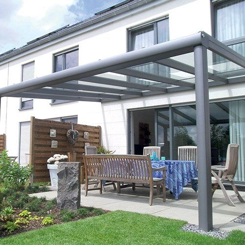 Pergola bioclimatique gris clair au-dessus d'une terrasse avec du mobilier extérieur en bois
