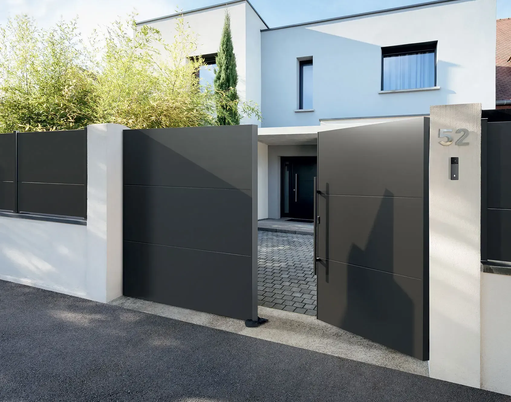 Portail battant en métal noir devant maison moderne