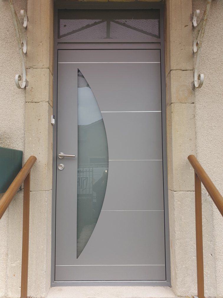 Porte grise en métal avec motifs géométriques et poignées en chrome.