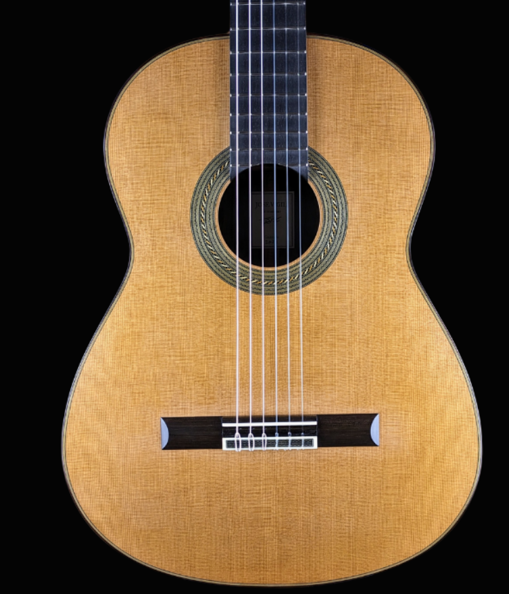 Guitarra clásica con acabado en madera clara, diapasón negro y roseta en la boca.