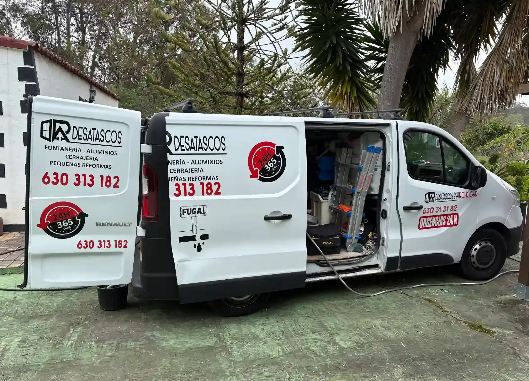 Hombre trabajando en un desagüe. Señal de precaución amarilla y equipo en un camino de hormigón, en una zona costera.