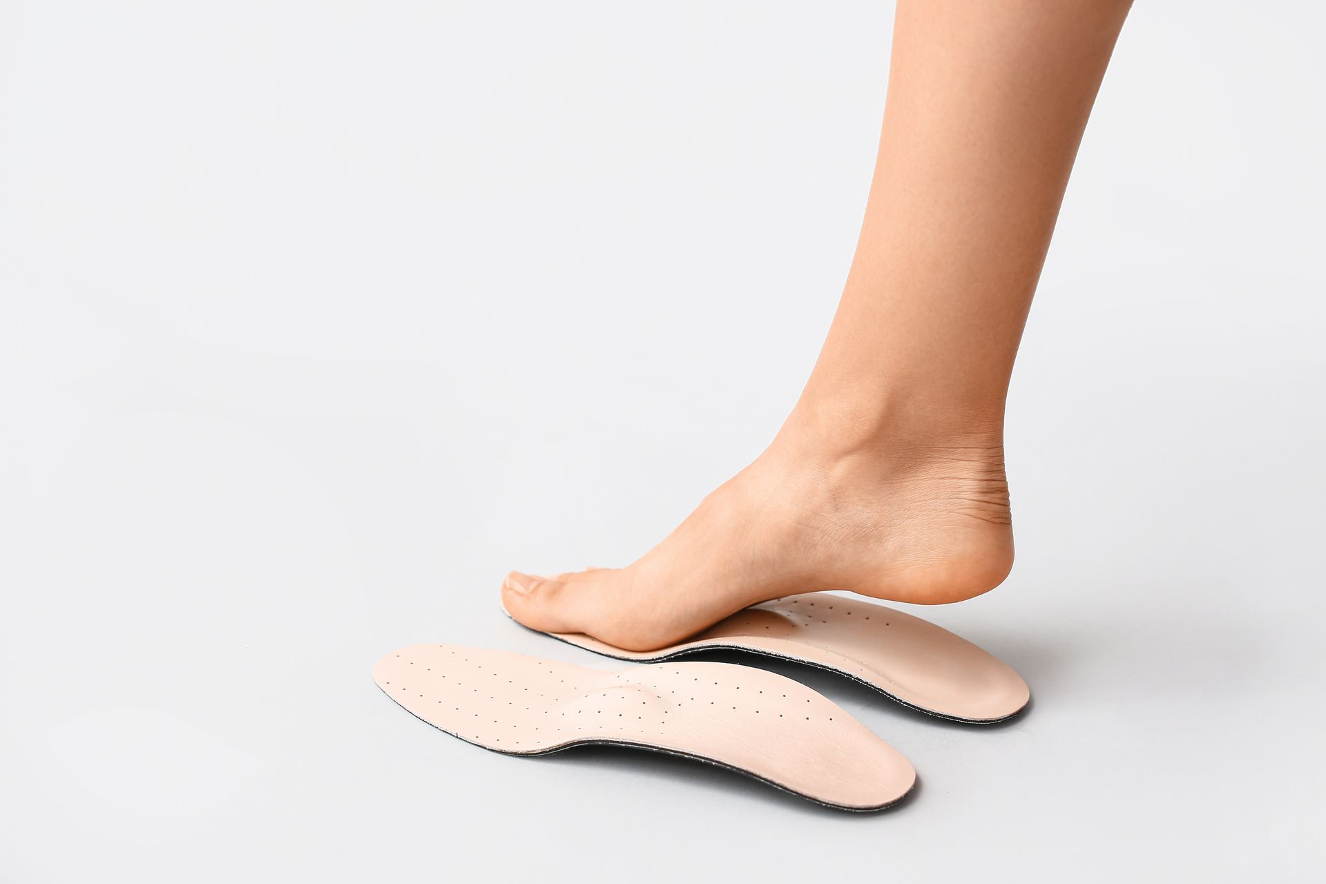 Pied avec semelles orthopédiques, montrant le soutien de la voûte plantaire.