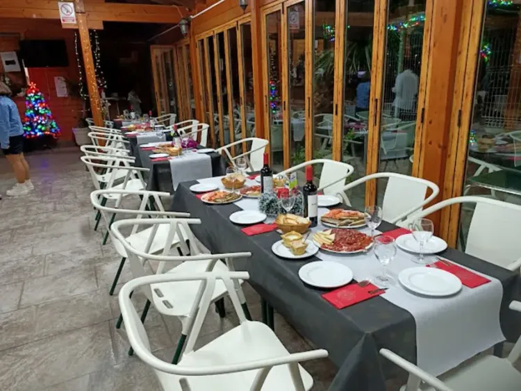 Una mesa larga con platos y vasos encima en un restaurante.