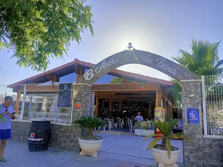 Un hombre está parado frente a un restaurante.