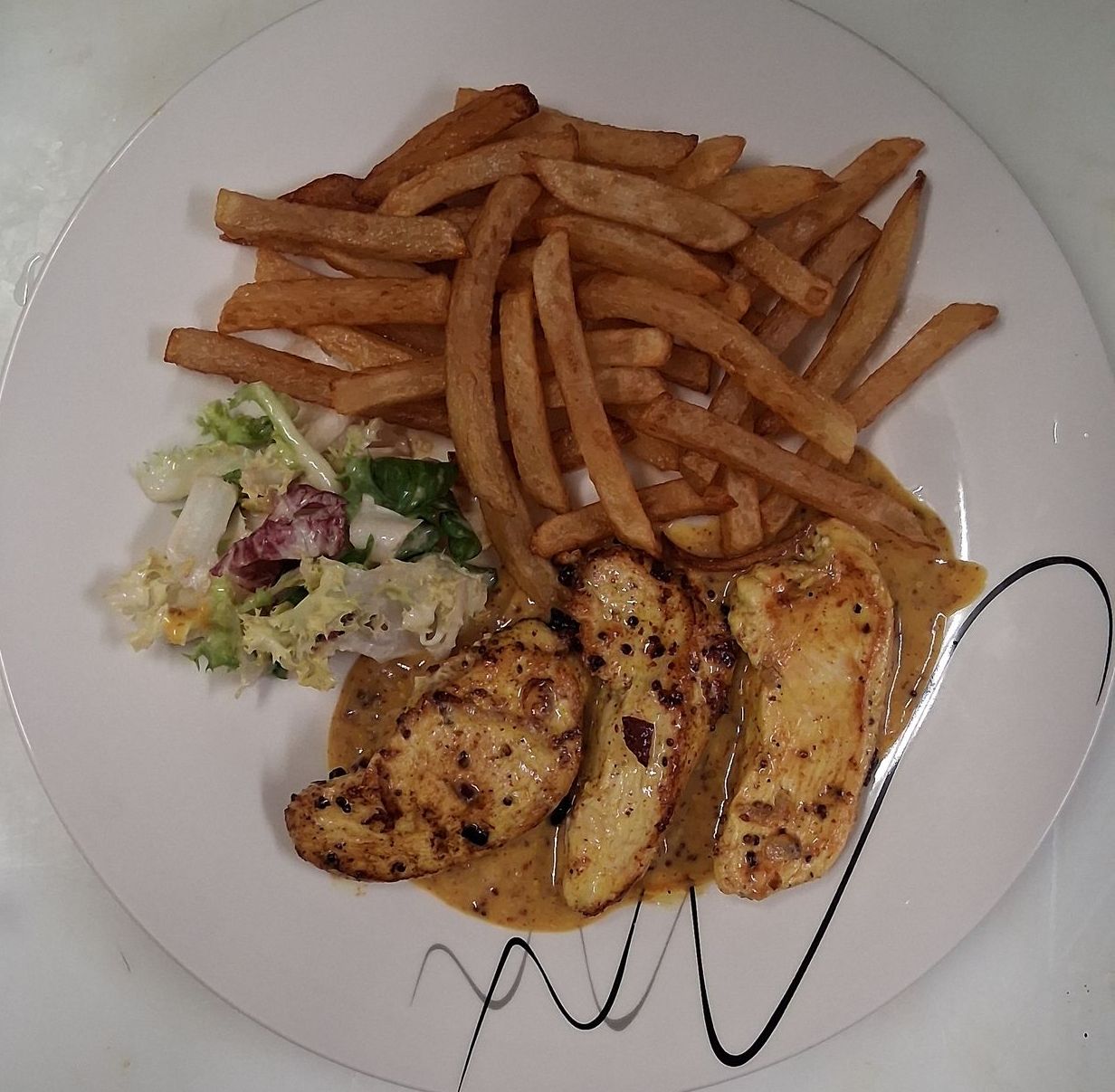 Une assiette de frite et blanc de poulet