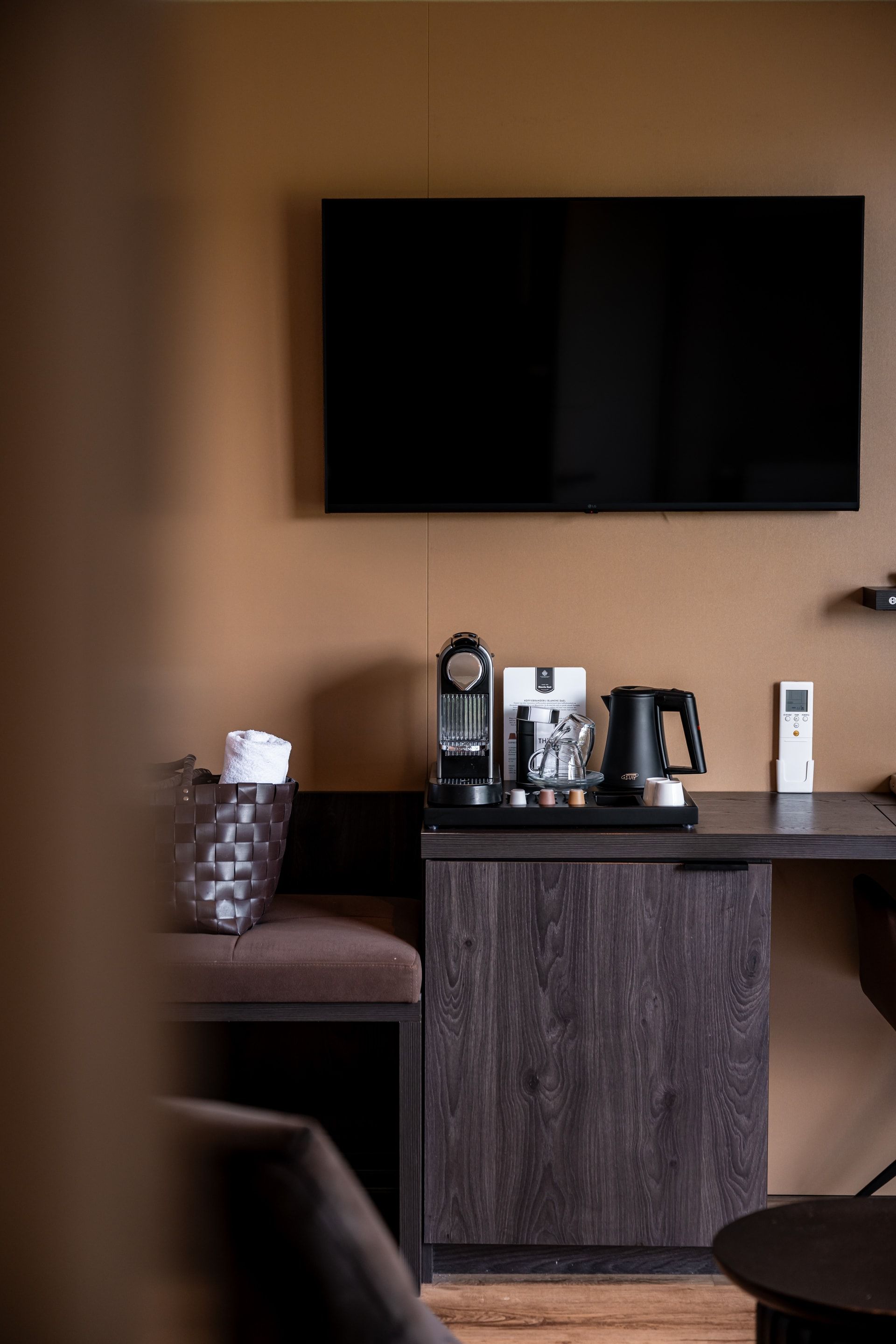 Een hotelkamer met een bureau en een flatscreen-tv.