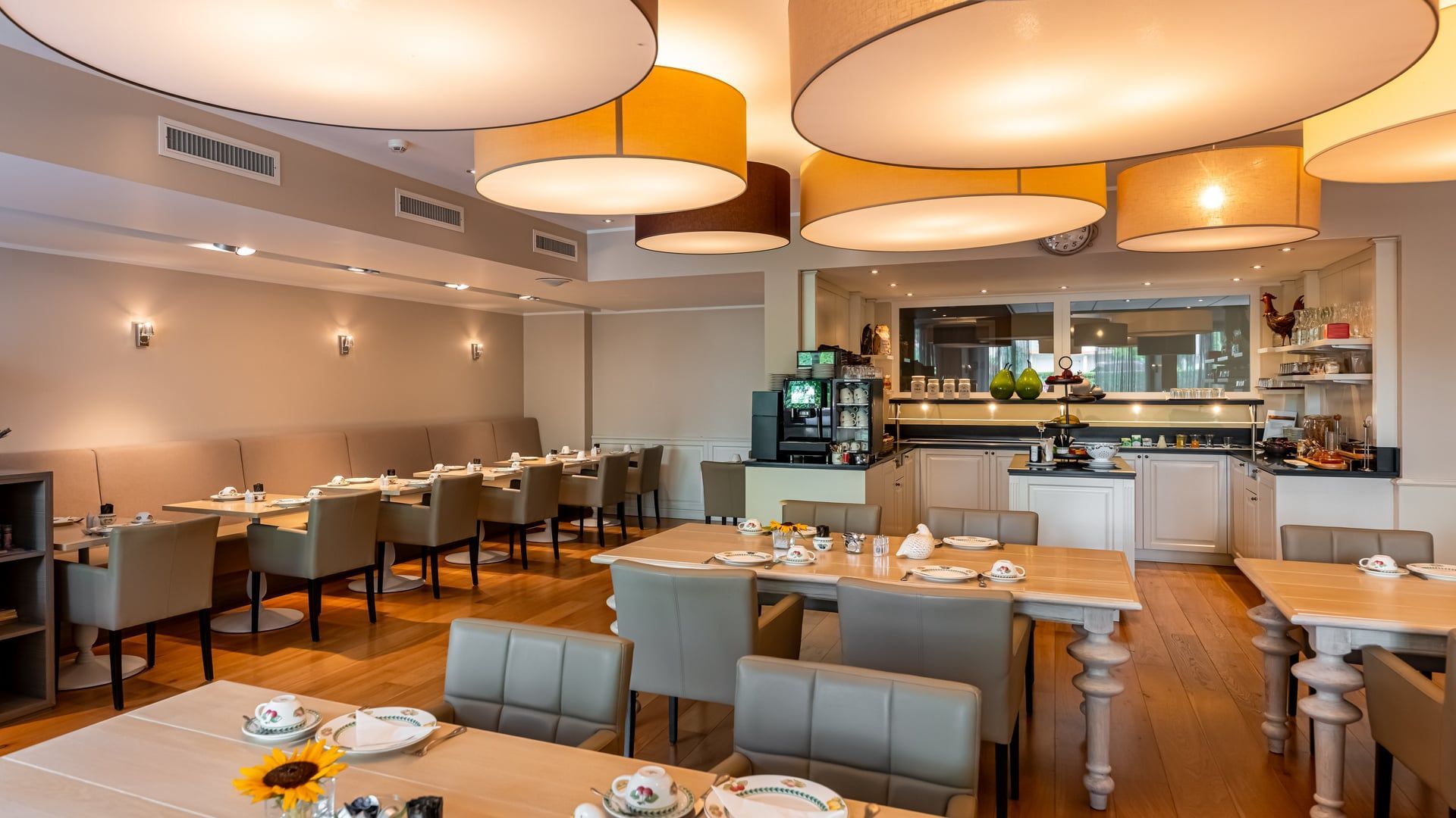 Een restaurant met tafels en stoelen en een chef-kok op de achtergrond.