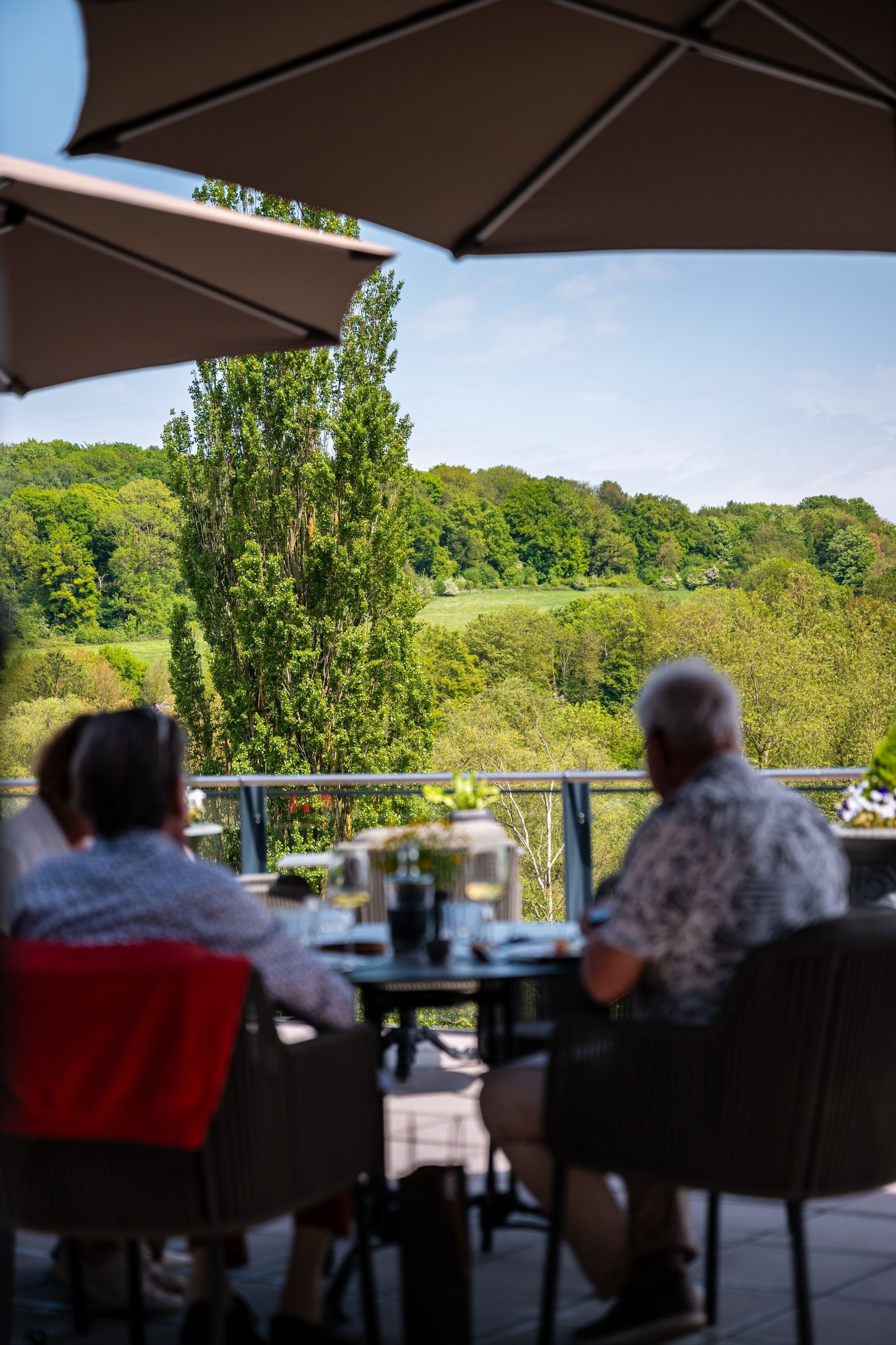 Een man en een vrouw zitten aan een tafel onder een parasol.