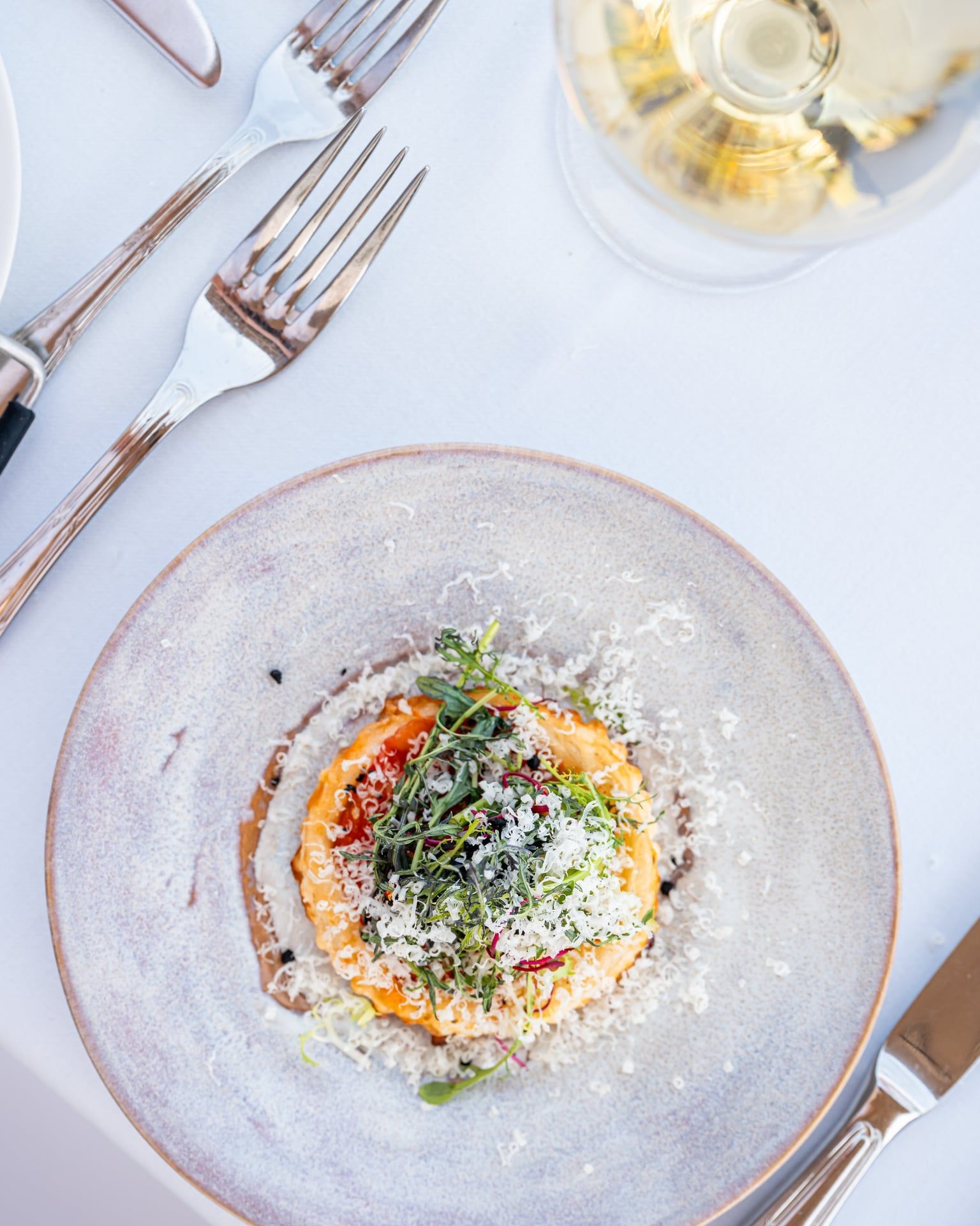 Een groot wit huis met veel ramen, omgeven door bomen.