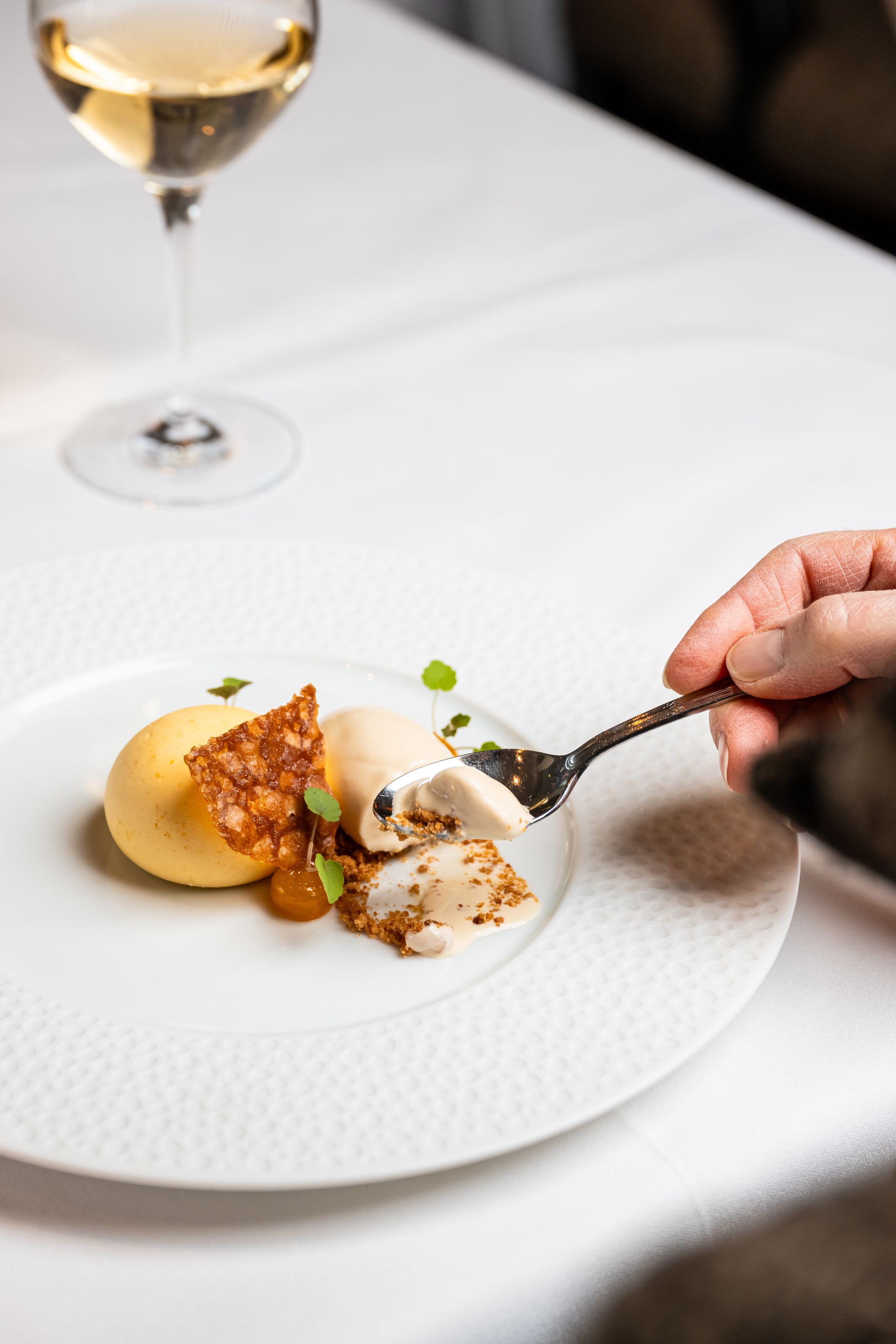 Een persoon houdt een vork boven een bord met eten.