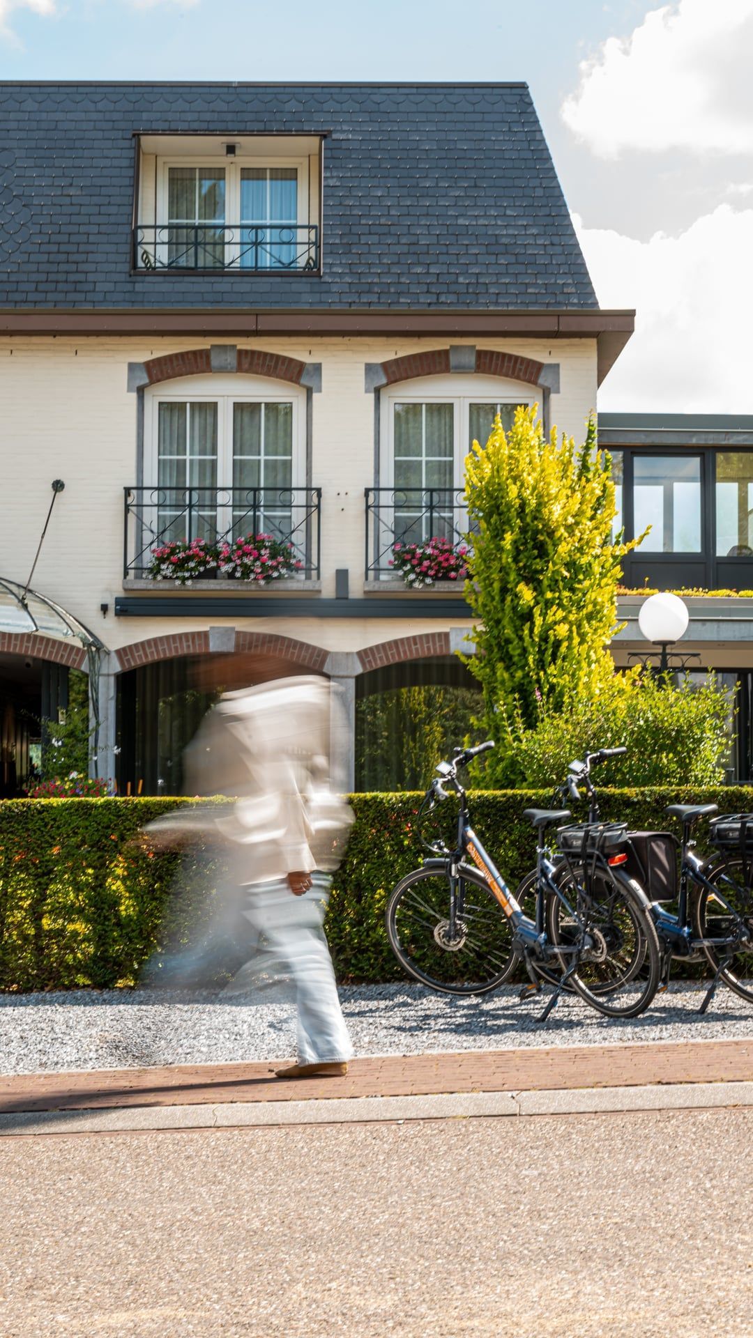 Een vrouw in een badjas zit op een ligstoel en leest een tijdschrift.