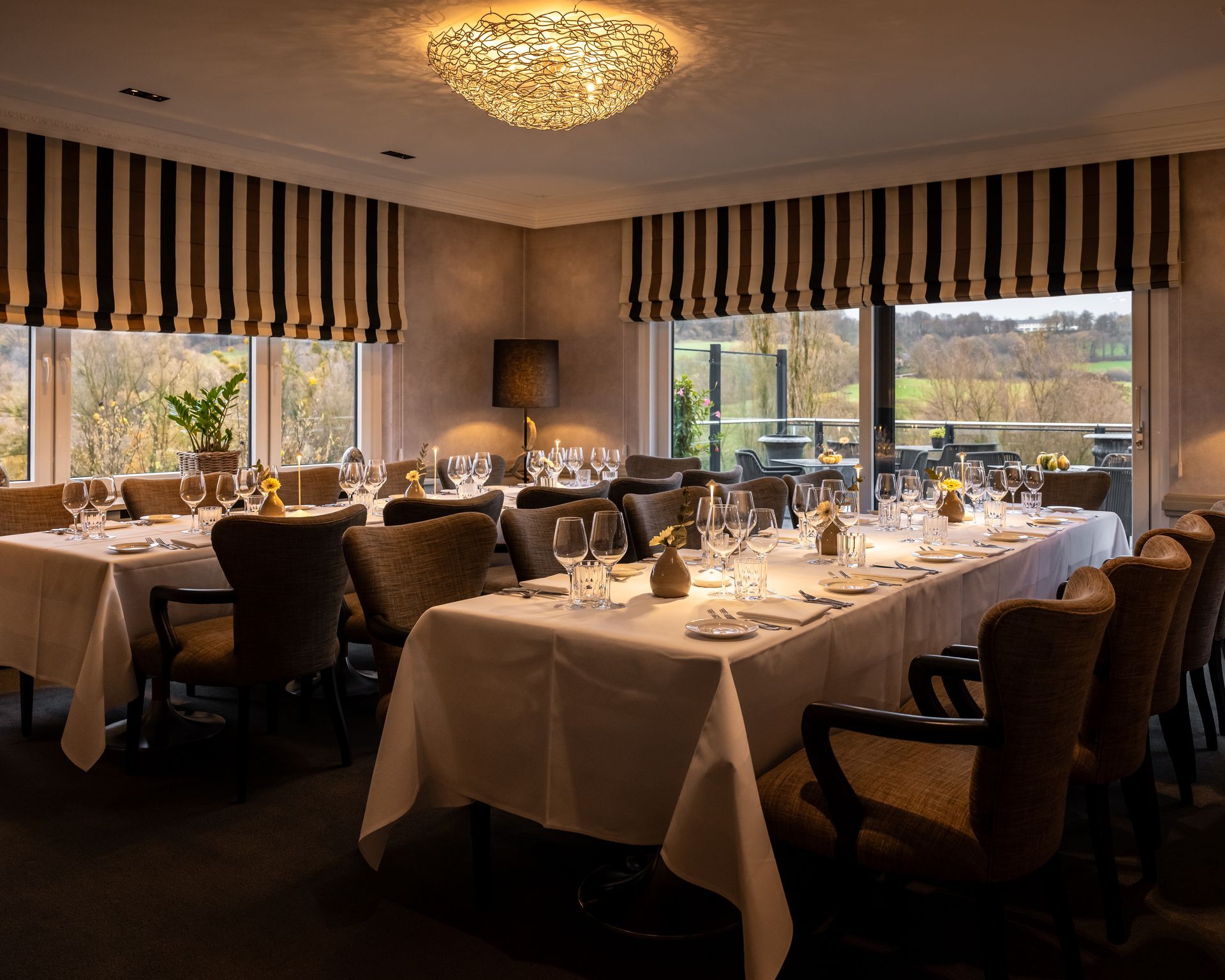 Een lange tafel met wijnglazen en een projectiescherm