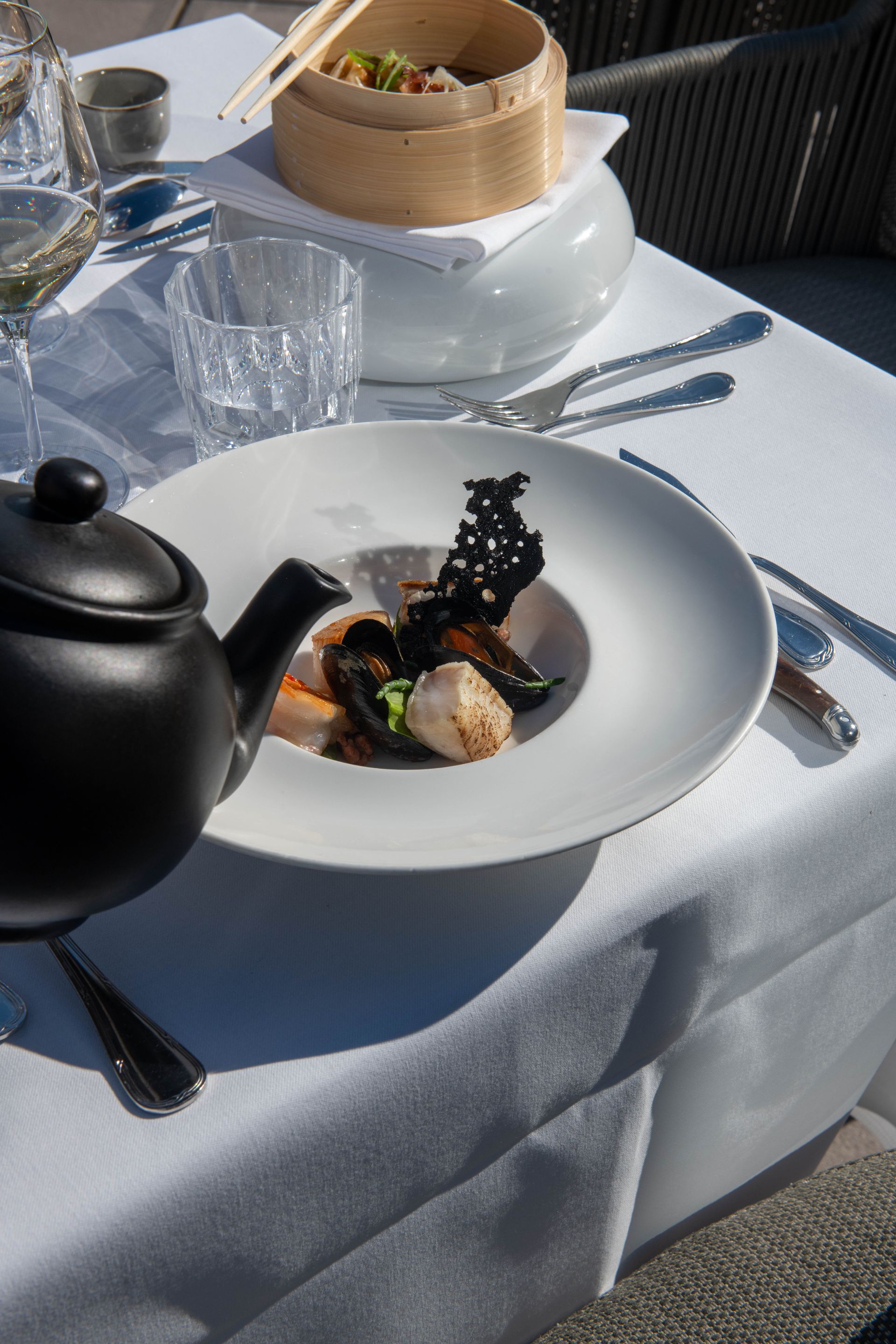 Een bord met eten staat op een tafel naast een theepot.