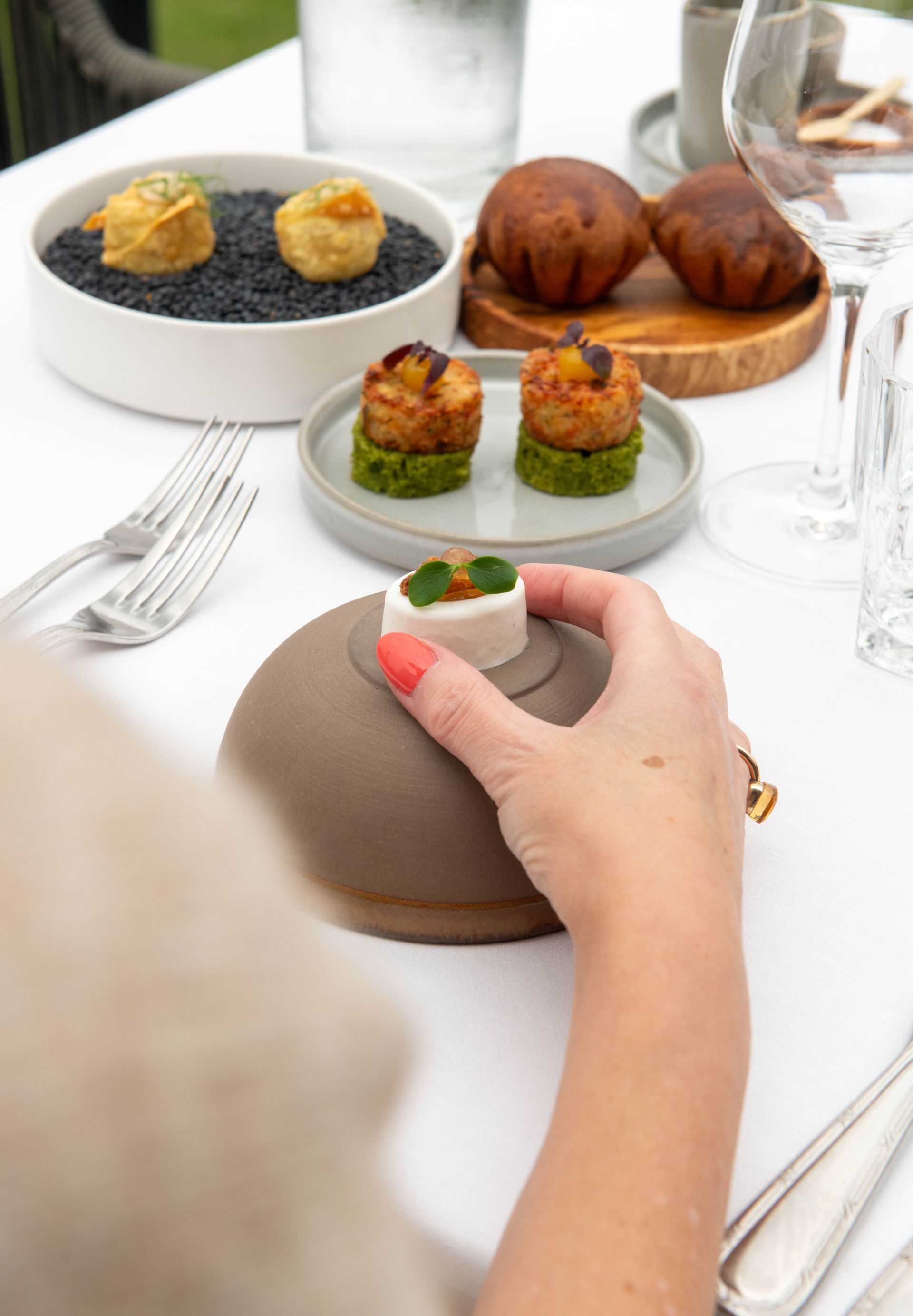 Een persoon zit aan een tafel met borden met eten erop.