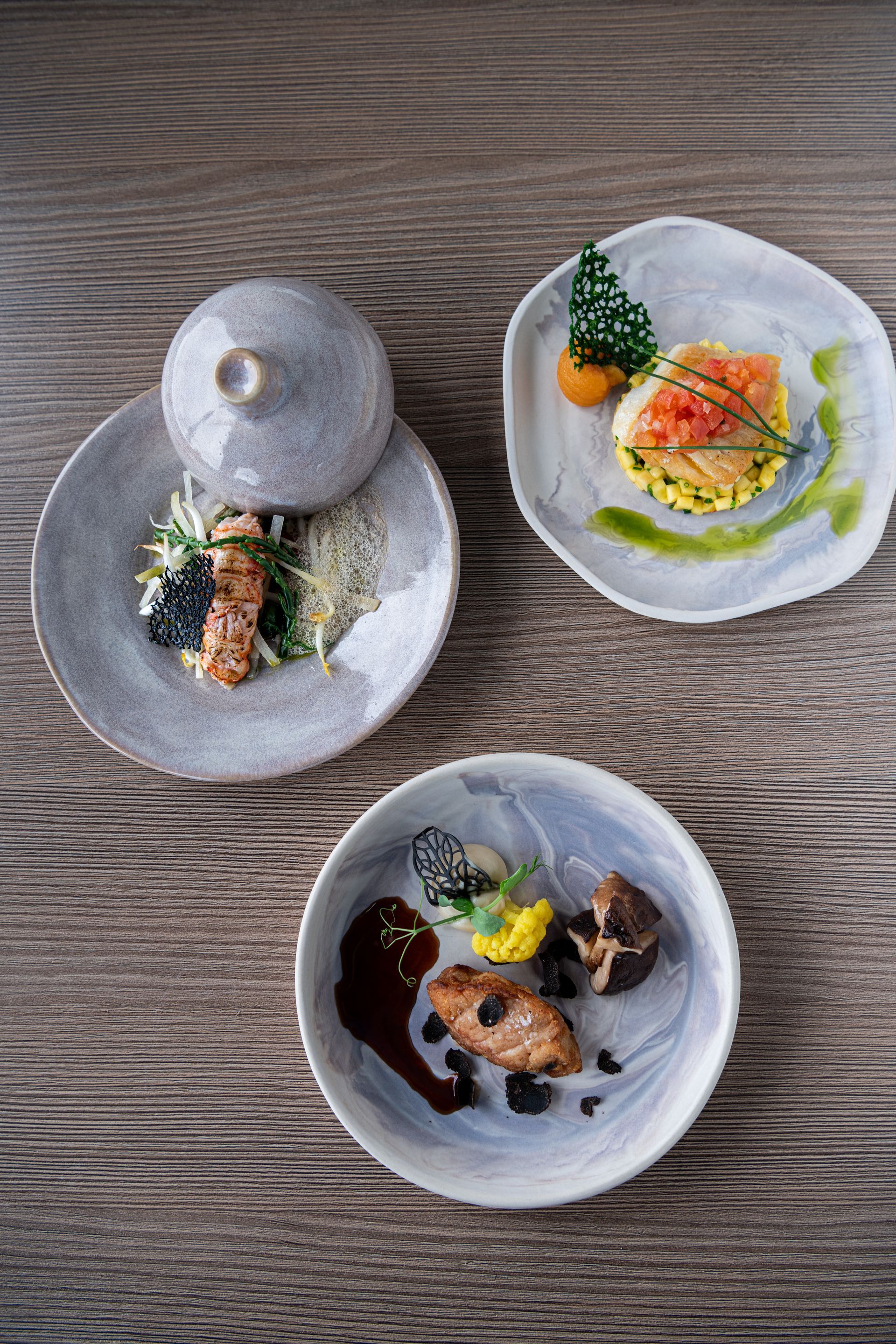 Op een houten tafel staan drie borden met eten.