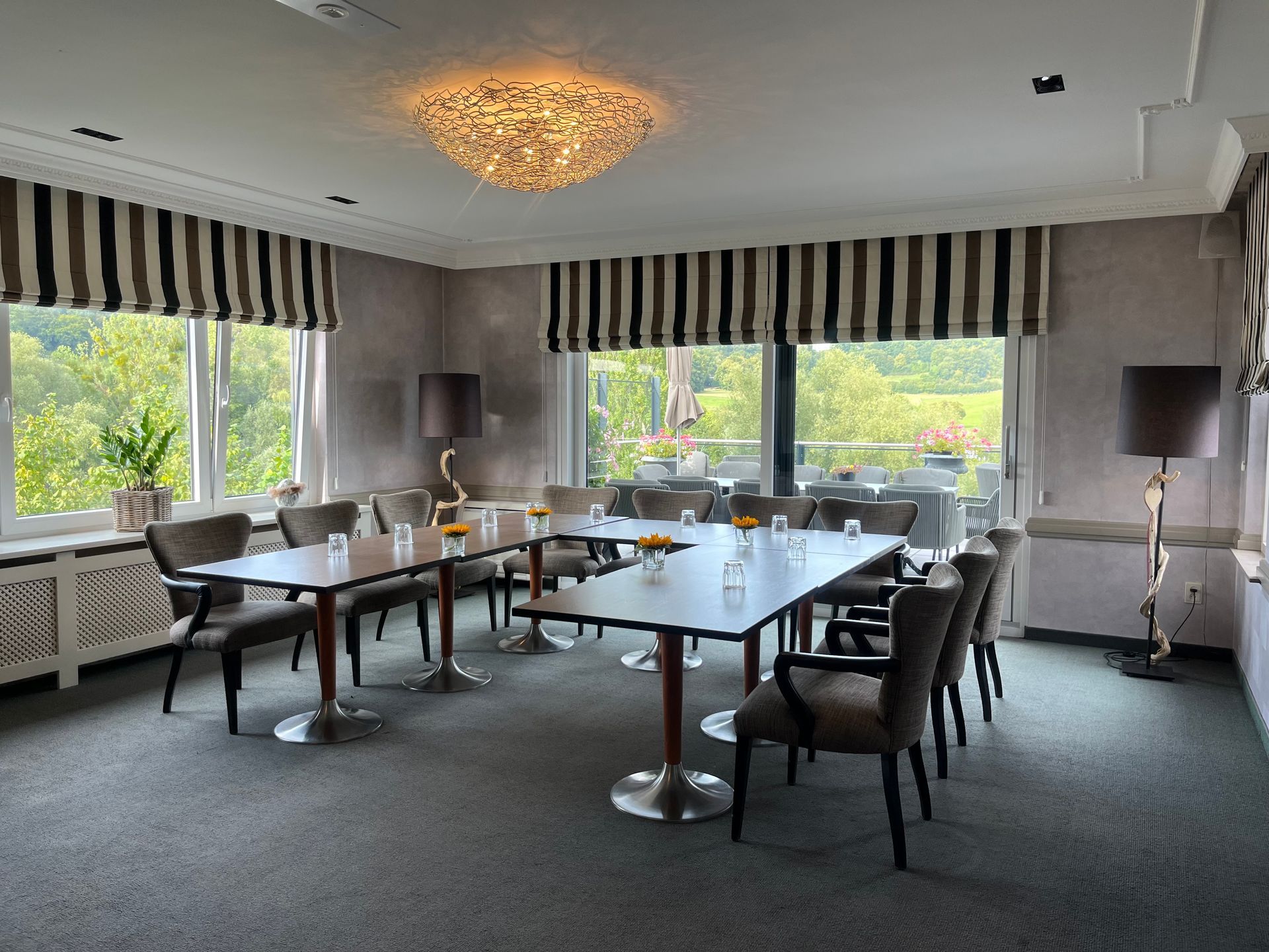 Een lange tafel met wijnglazen en een projectiescherm