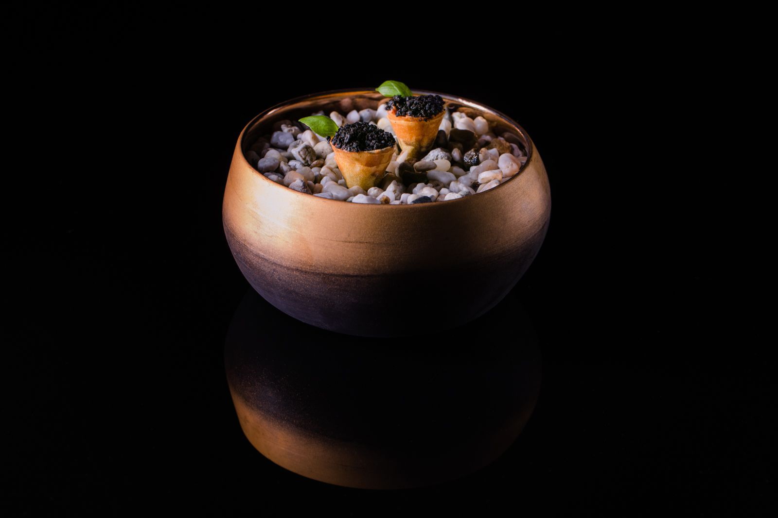 Eine mit Essen gefüllte Holzschüssel auf schwarzem Hintergrund.