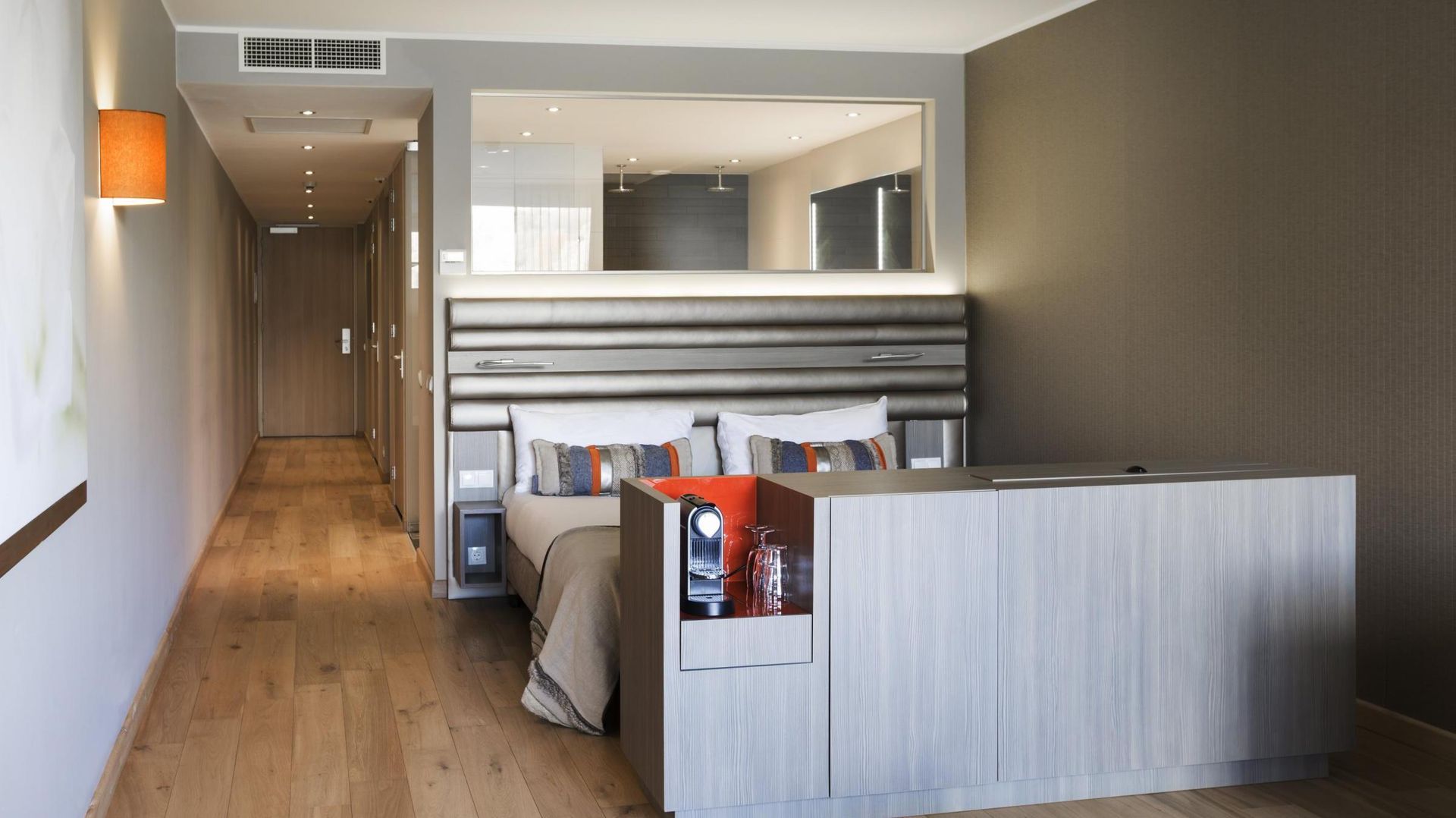 Een hotelkamer met een bed en een spiegel