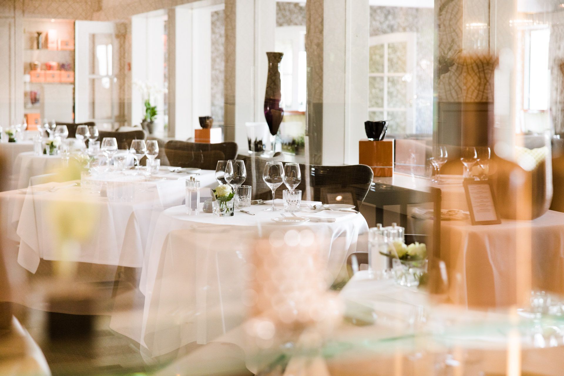 Een restaurant met tafels en stoelen die klaar staan ​​voor een maaltijd.