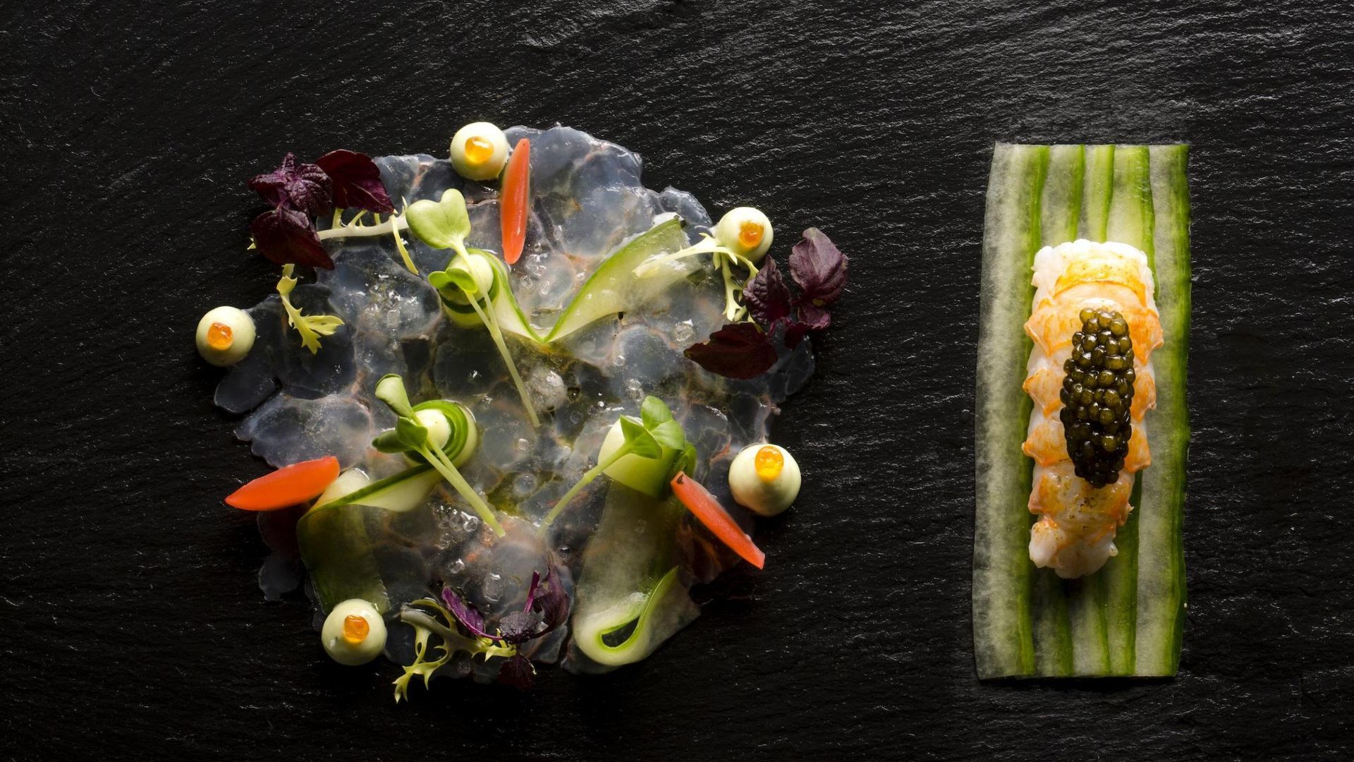 Ein Teller mit Garnelen und Kaviar auf einer Gurkenscheibe