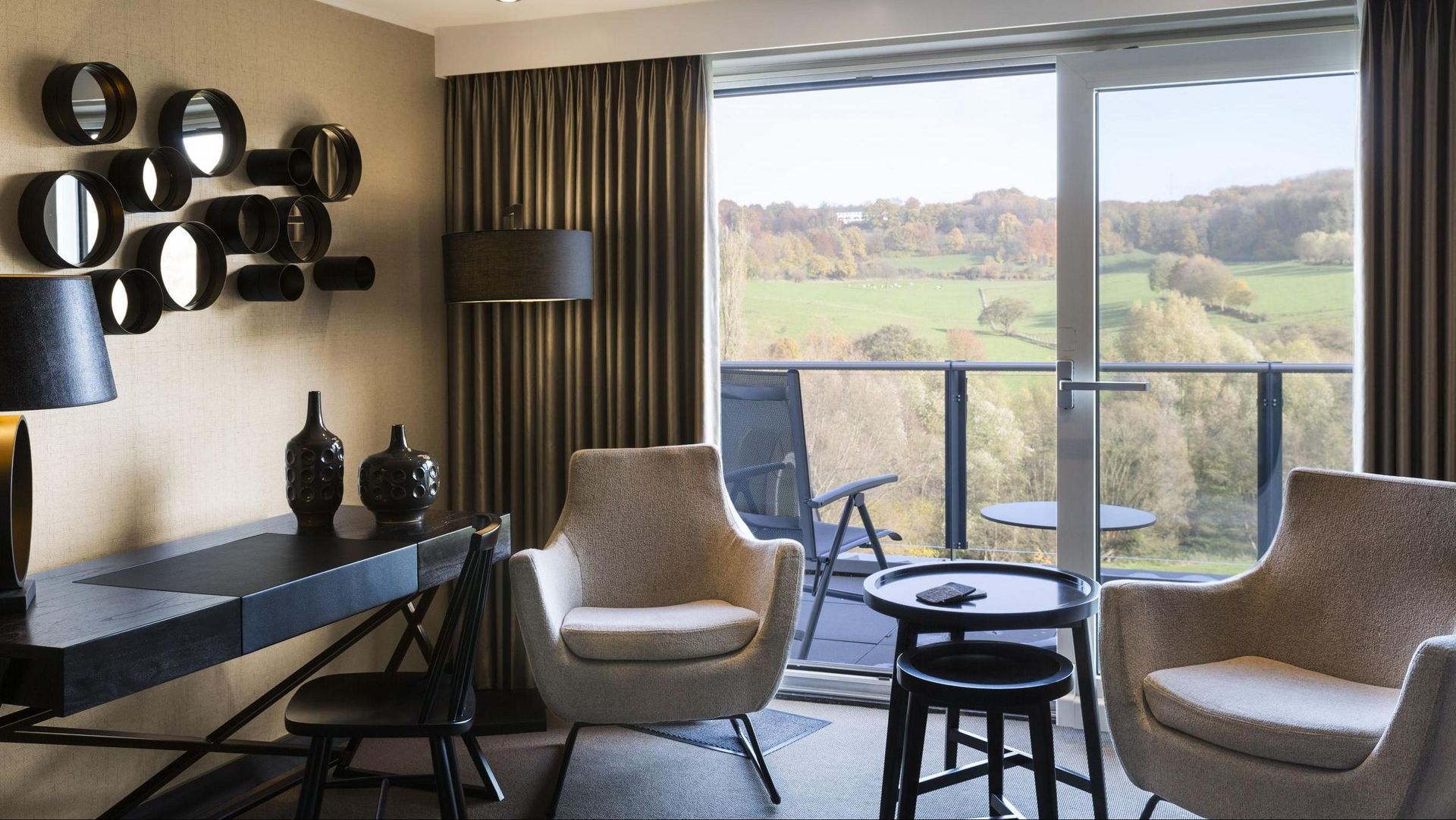 Een woonkamer met twee stoelen, een tafel en een balkon