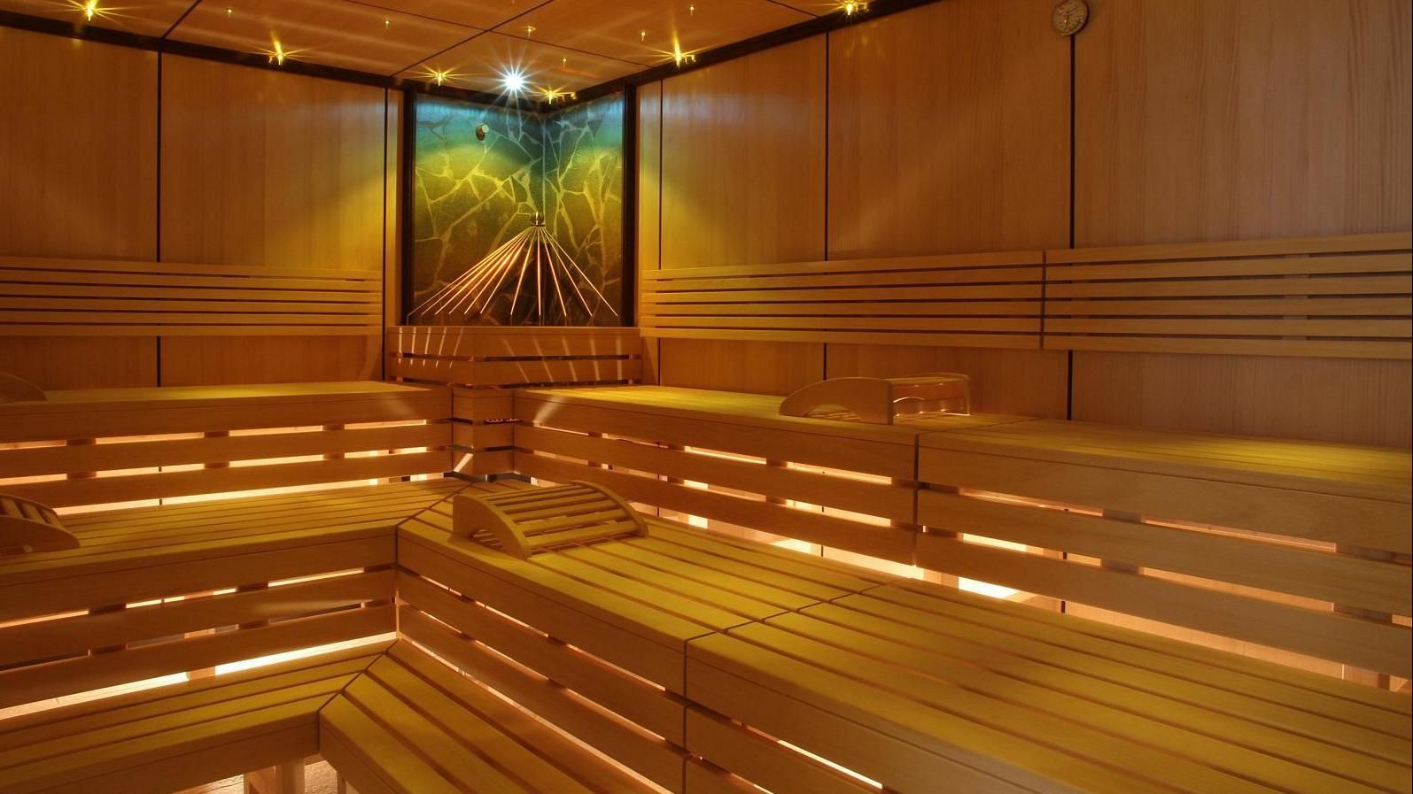 Een houten sauna met een schilderij aan de muur.