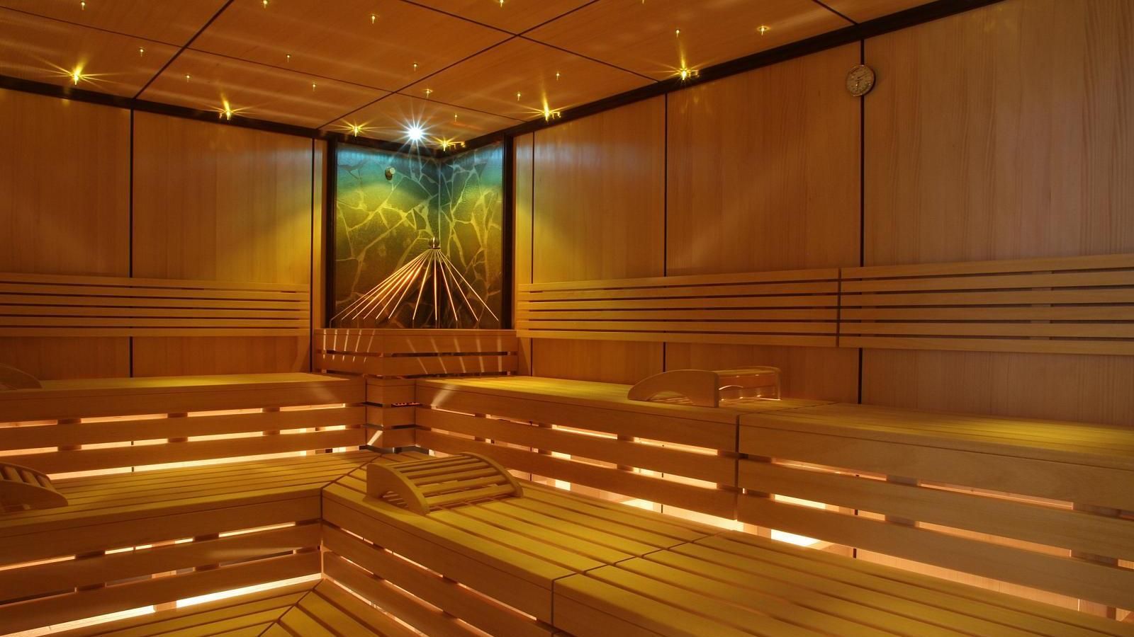 Een houten sauna met een schilderij aan de muur.