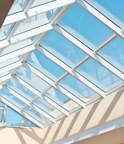 Un techo de cristal con un cielo azul detrás.