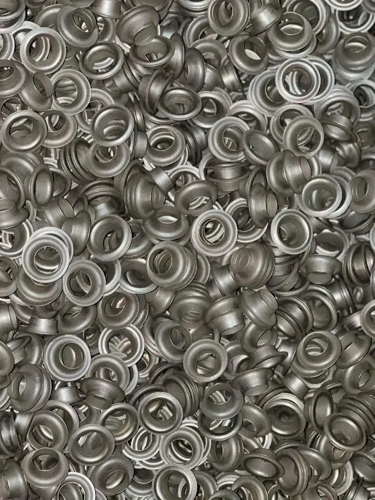 Pila de ojales de metal plateado, vista de arriba hacia abajo.