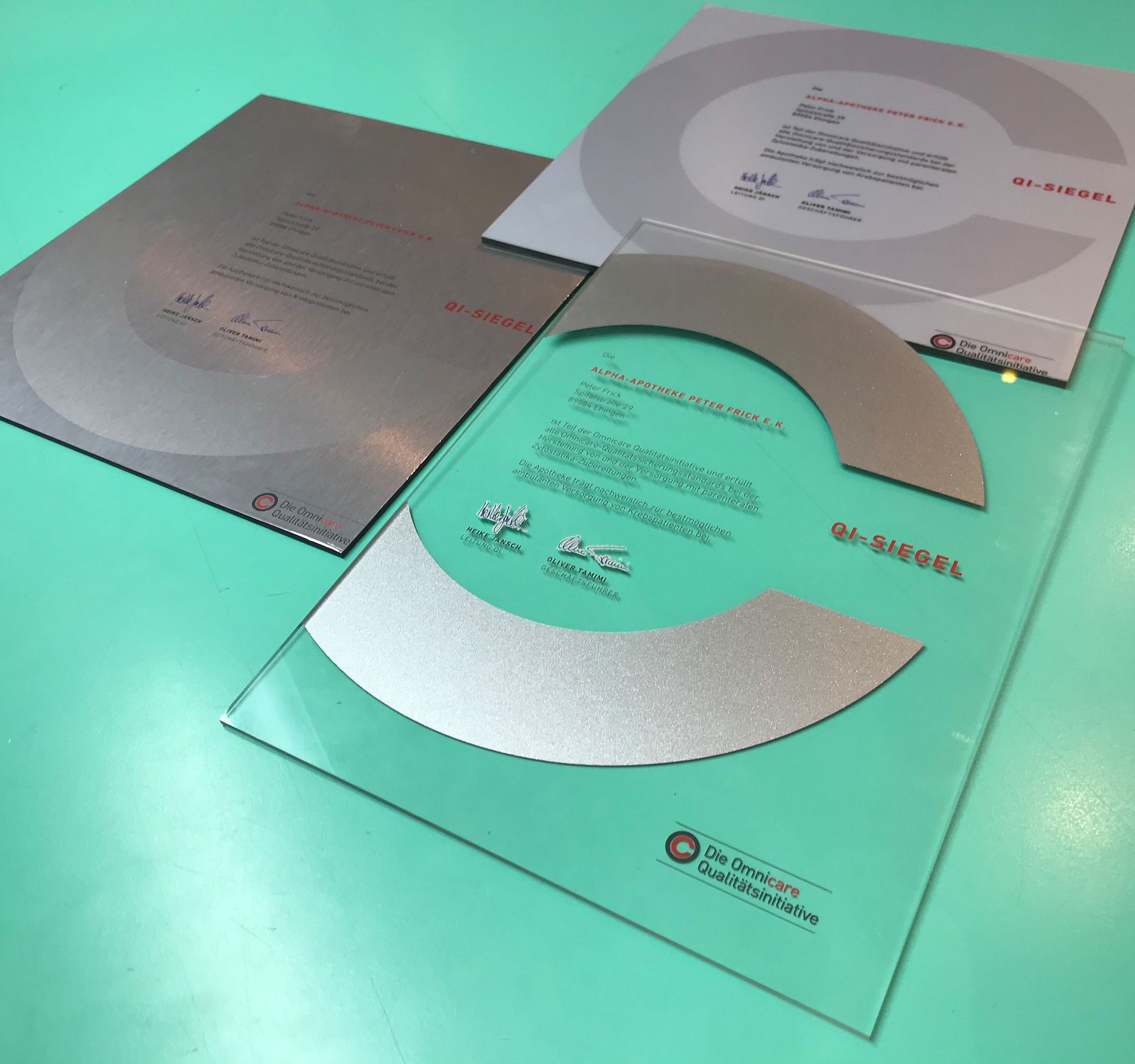 Drei Blätter Papier auf einem Tisch, eines davon hat einen Kreis darauf