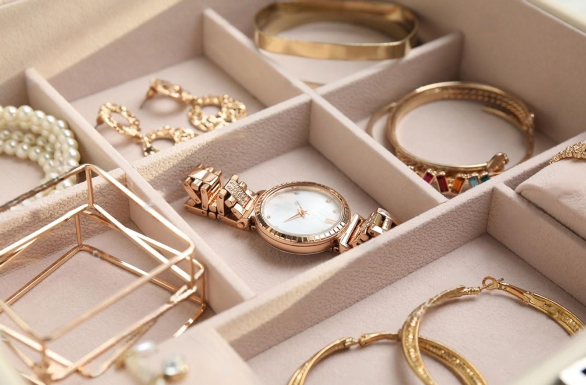 Schmuckschatulle mit Gold- und Perlenschmuck: Armbänder, Ohrringe, Halskette, Uhr.